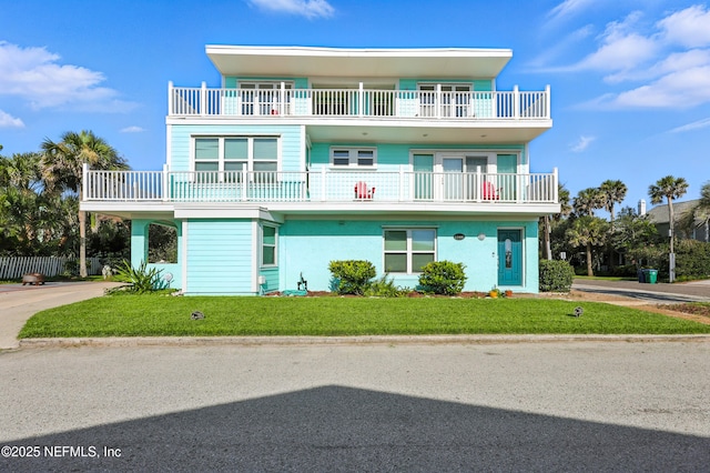 1506 Strand St, Neptune Beach, FL 32266 - view of front of property with a balcony, a front yard, and concrete driveway
