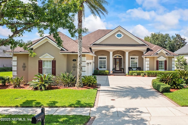 641 Donald Ross Way, Saint Augustine, FL 32092 - view of front facade featuring stucco siding, concrete driveway, a front yard, covered porch, and a garage