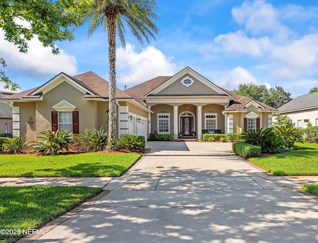 641 Donald Ross Way, Saint Augustine, FL 32092 - neoclassical / greek revival house featuring stucco siding, concrete driveway, an attached garage, and a front yard