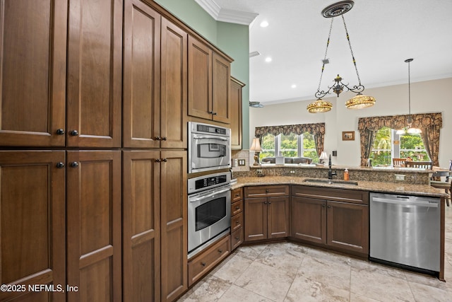 641 Donald Ross Way, Saint Augustine, FL 32092 - kitchen featuring appliances with stainless steel finishes, crown molding, stone countertops, a peninsula, and hanging light fixtures