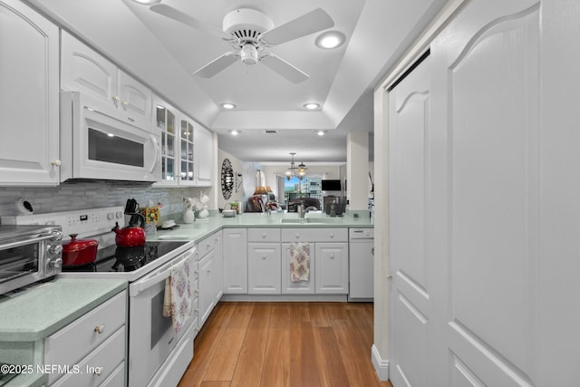 3060 N Atlantic Ave Unit 708, Cocoa Beach, FL 32931 - kitchen with white appliances, glass insert cabinets, a ceiling fan, light countertops, and light wood finished floors
