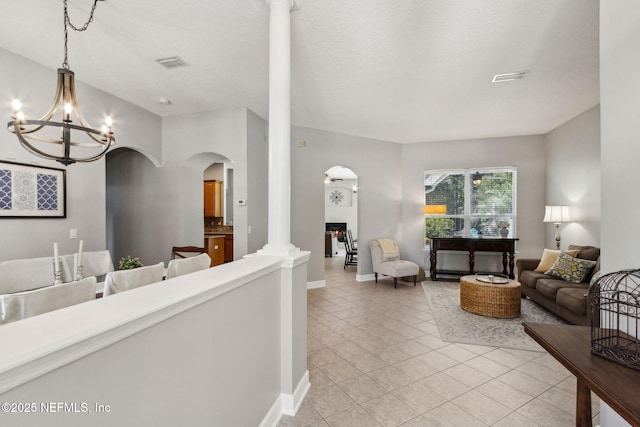 14220 Palmetto Springs St, Jacksonville, FL 32258 - living area with arched walkways, light tile patterned floors, ornate columns, and a chandelier