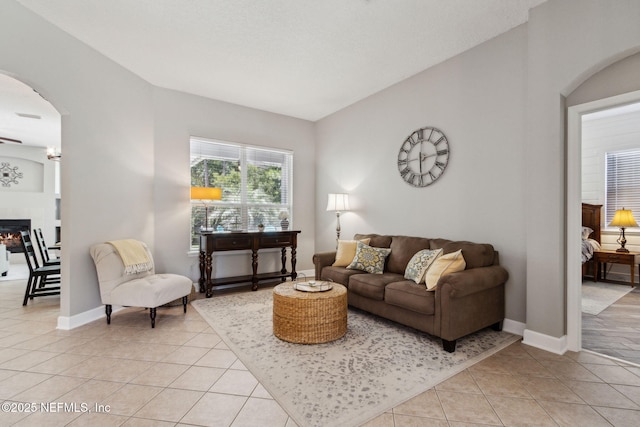 14220 Palmetto Springs St, Jacksonville, FL 32258 - living area featuring arched walkways, light tile patterned floors, a glass covered fireplace, and lofted ceiling