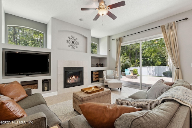 14220 Palmetto Springs St, Jacksonville, FL 32258 - living room featuring built in features, tile patterned flooring, a tile fireplace, a ceiling fan, and a textured ceiling