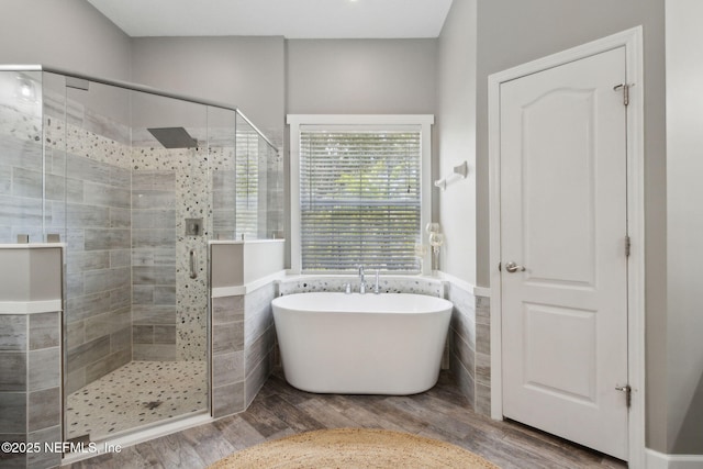 14220 Palmetto Springs St, Jacksonville, FL 32258 - full bath with a soaking tub, a shower stall, wood finished floors, tile walls, and a wainscoted wall