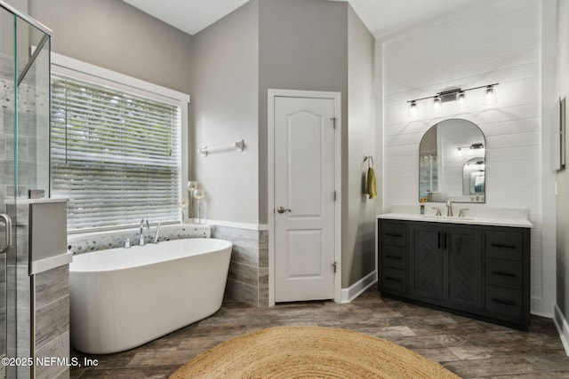 14220 Palmetto Springs St, Jacksonville, FL 32258 - bathroom with vanity, a freestanding tub, a shower stall, wood finished floors, and tile walls