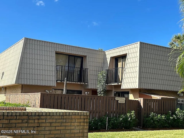 5706 57th Way, West Palm Beach, FL 33409 - view of property exterior with mansard roof, stucco siding, and brick siding
