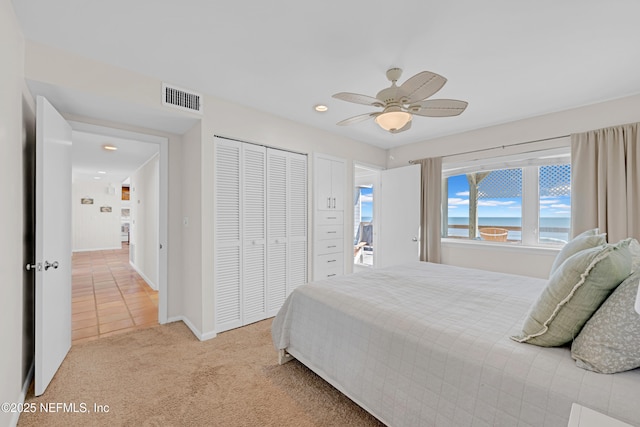 2947 S Ponte Vedra Blvd, Ponte Vedra Beach, FL 32082 - bedroom with light colored carpet, a closet, a water view, a ceiling fan, and recessed lighting