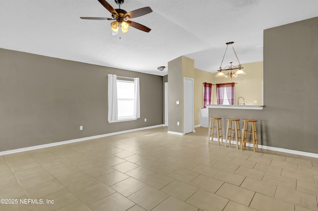 1908 Longneedle Ln, Middleburg, FL 32068 - unfurnished living room featuring vaulted ceiling, ceiling fan, baseboards, a textured ceiling, and light tile patterned floors