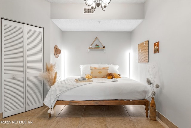 4000 Grande Vista Blvd Unit 15-206, Saint Augustine, FL 32084 - bedroom with a closet, tile patterned floors, a textured ceiling, and a chandelier