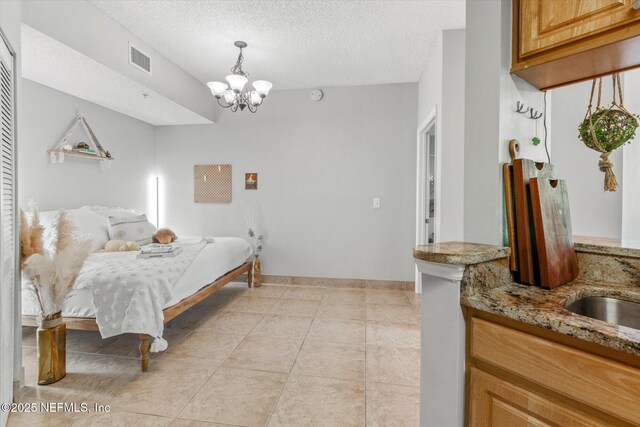 4000 Grande Vista Blvd Unit 15-206, Saint Augustine, FL 32084 - bedroom with a chandelier, a textured ceiling, and light tile patterned floors