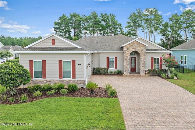 17 Derecho Ln, Saint Augustine, FL 32095 - view of front of house featuring stone siding, decorative driveway, and a shingled roof
