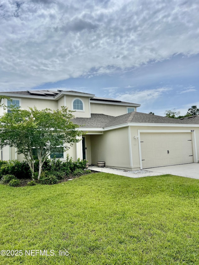 8657 Lake George Cir E, Macclenny, FL 32063 - view of front of home featuring an attached garage, concrete driveway, a front lawn, solar panels, and stucco siding