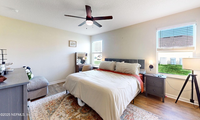 8657 Lake George Cir E, Macclenny, FL 32063 - bedroom featuring wood finished floors, multiple windows, a textured ceiling, and a ceiling fan