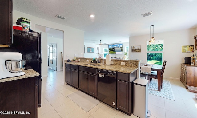 8657 Lake George Cir E, Macclenny, FL 32063 - kitchen with black appliances, ceiling fan, dark brown cabinets, light stone countertops, and light tile patterned flooring