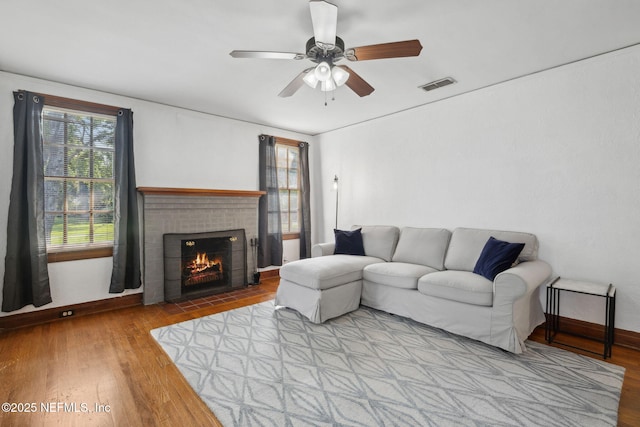 1094 Wolfe St, Jacksonville, FL 32205 - living room with wood finished floors, a brick fireplace, and a ceiling fan