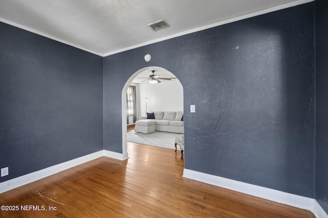 1094 Wolfe St, Jacksonville, FL 32205 - unfurnished room featuring arched walkways, wood finished floors, ceiling fan, ornamental molding, and a textured wall