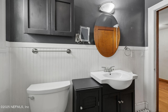 1094 Wolfe St, Jacksonville, FL 32205 - half bathroom with wainscoting, vanity, and wood finished floors