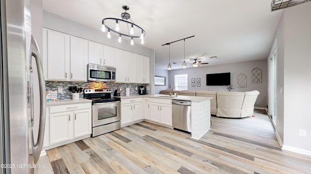 1441 Laurel Oak Dr, Fleming Island, FL 32003 - kitchen with appliances with stainless steel finishes, a sink, open floor plan, decorative backsplash, and light countertops