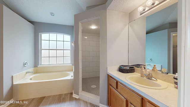 1441 Laurel Oak Dr, Fleming Island, FL 32003 - full bath featuring vanity, a garden tub, a textured ceiling, tiled shower, and wood finished floors