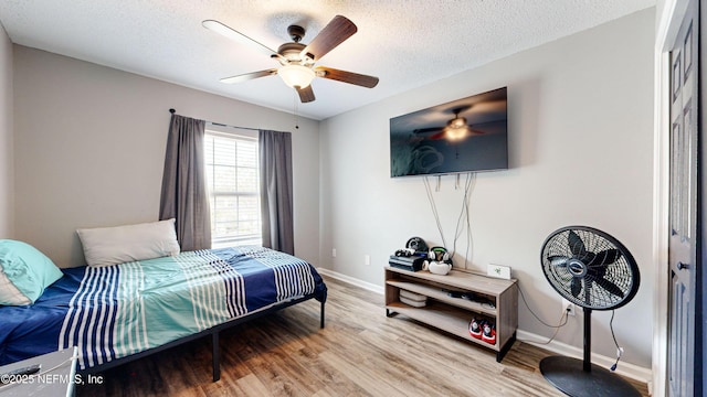 1441 Laurel Oak Dr, Fleming Island, FL 32003 - bedroom featuring baseboards, wood finished floors, a textured ceiling, and ceiling fan