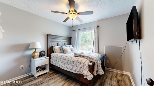 1441 Laurel Oak Dr, Fleming Island, FL 32003 - bedroom featuring baseboards, wood finished floors, a textured ceiling, and a ceiling fan