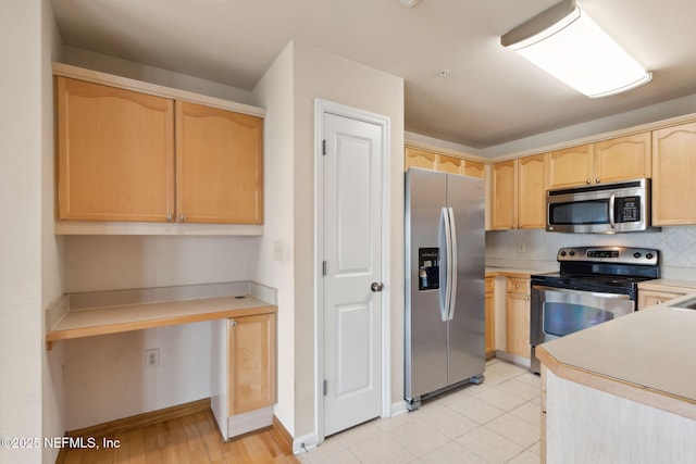 400 E Bay St Unit 401, Jacksonville, FL 32202 - kitchen with stainless steel appliances, light brown cabinetry, tasteful backsplash, light countertops, and built in study area