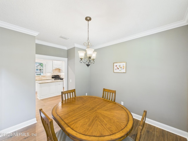 96168 High Pointe Dr, Fernandina Beach, FL 32034 - dining space with a chandelier, light wood-style flooring, and ornamental molding