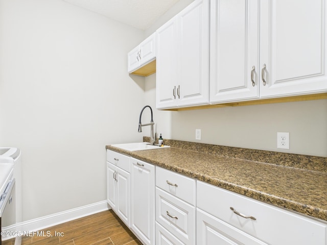 96168 High Pointe Dr, Fernandina Beach, FL 32034 - kitchen featuring dark countertops, wood finished floors, and white cabinetry