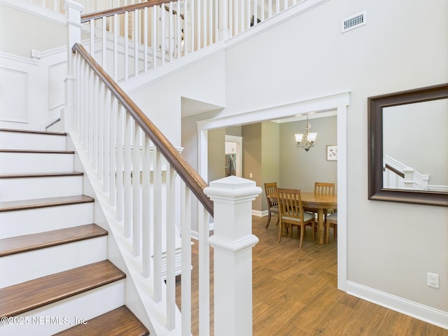 96168 High Pointe Dr, Fernandina Beach, FL 32034 - staircase with wood finished floors, a chandelier, and a high ceiling