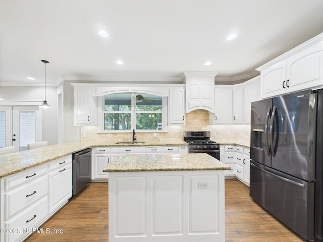 96168 High Pointe Dr, Fernandina Beach, FL 32034 - kitchen featuring appliances with stainless steel finishes, a peninsula, ornamental molding, white cabinetry, and a kitchen island