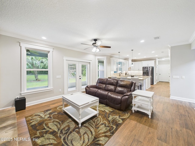 96168 High Pointe Dr, Fernandina Beach, FL 32034 - living area featuring french doors, crown molding, ceiling fan, light wood-type flooring, and recessed lighting