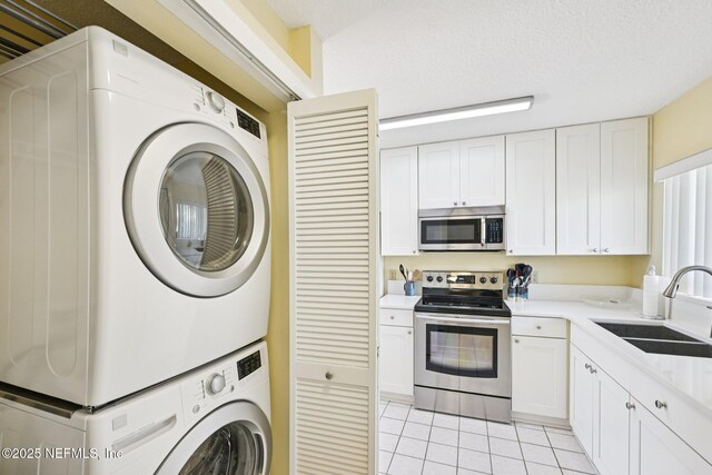 3960 A1A S Unit 505, Saint Augustine Beach, FL 32080 - washroom with stacked washing machine and dryer and light tile patterned flooring