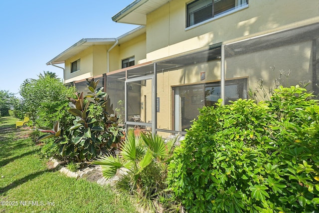 3960 A1A S Unit 505, Saint Augustine Beach, FL 32080 - rear view of house featuring stucco siding and glass enclosure