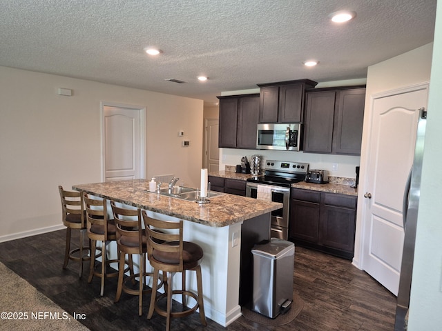 2420 Cold Stream Ln, Green Cove Springs, FL 32043 - kitchen with appliances with stainless steel finishes, a sink, an island with sink, dark wood-style floors, and recessed lighting