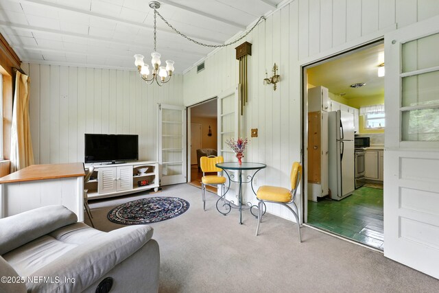1206 Nightingale Ct, Jacksonville, FL 32216 - carpeted living area featuring a chandelier and wooden walls