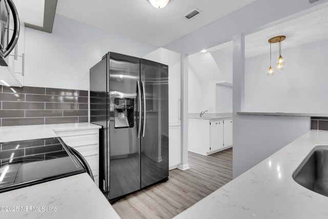 9360 Craven Rd Unit 703, Jacksonville, FL 32257 - kitchen with fridge with ice dispenser, backsplash, white cabinets, light stone countertops, and pendant lighting