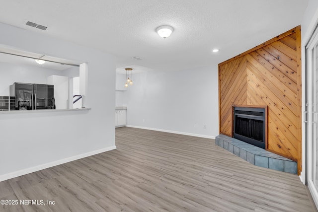 9360 Craven Rd Unit 703, Jacksonville, FL 32257 - unfurnished living room featuring a fireplace, wood finished floors, wood walls, recessed lighting, and a chandelier