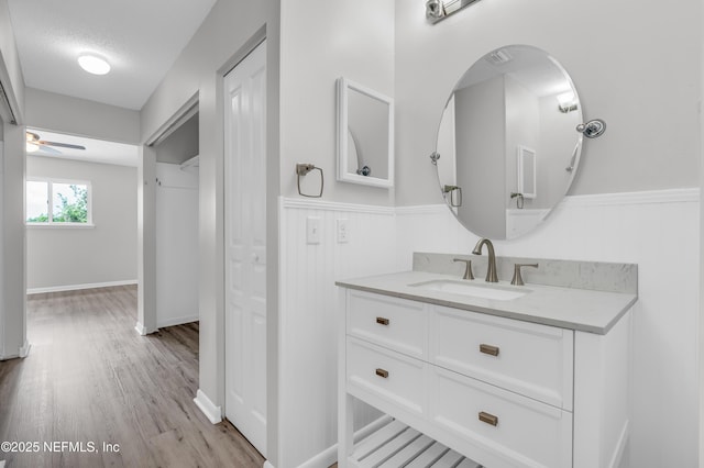 9360 Craven Rd Unit 703, Jacksonville, FL 32257 - bathroom with vanity, wood finished floors, a ceiling fan, and wainscoting