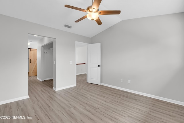 9360 Craven Rd Unit 703, Jacksonville, FL 32257 - unfurnished bedroom featuring lofted ceiling, light wood finished floors, a ceiling fan, and a walk in closet