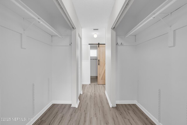 9360 Craven Rd Unit 703, Jacksonville, FL 32257 - walk in closet featuring a barn door and wood finished floors