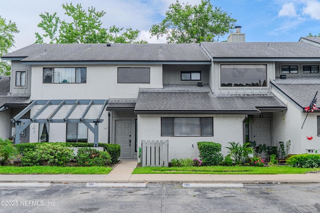 9360 Craven Rd Unit 703, Jacksonville, FL 32257 - view of front of house featuring a chimney, roof with shingles, uncovered parking, and stucco siding