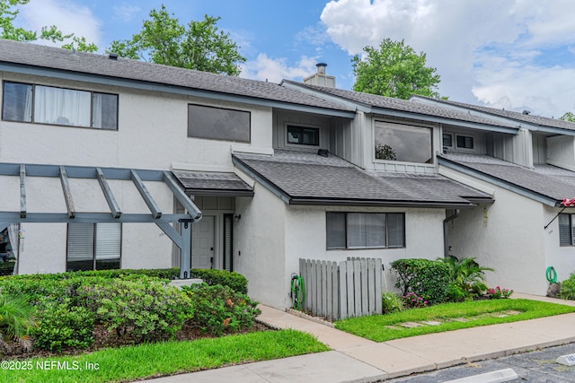 9360 Craven Rd Unit 703, Jacksonville, FL 32257 - view of front facade featuring stucco siding, a shingled roof, and a chimney