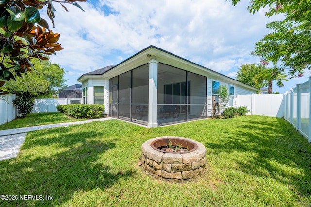 97082 Harbor Concourse Cir, Fernandina Beach, FL 32034 - back of property featuring a sunroom, a fenced backyard, and a fire pit