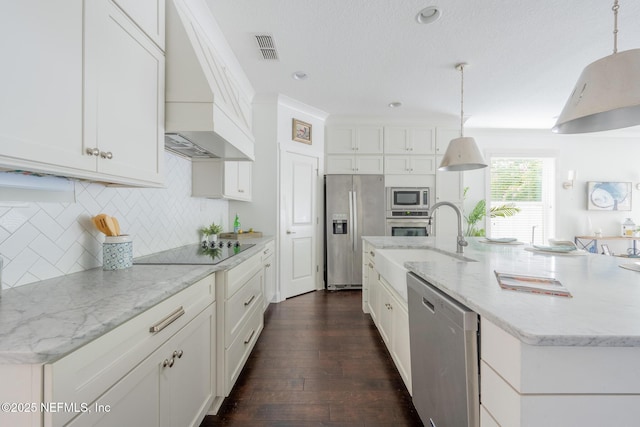 97082 Harbor Concourse Cir, Fernandina Beach, FL 32034 - kitchen with stainless steel appliances, custom exhaust hood, white cabinetry, a kitchen island with sink, and tasteful backsplash