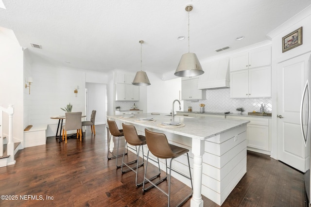 97082 Harbor Concourse Cir, Fernandina Beach, FL 32034 - kitchen featuring custom exhaust hood, dark wood-style floors, tasteful backsplash, white cabinetry, and black electric stovetop