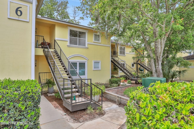 1800 The Greens Way Unit 605, Jacksonville Beach, FL 32250 - rear view of property with stairs and stucco siding