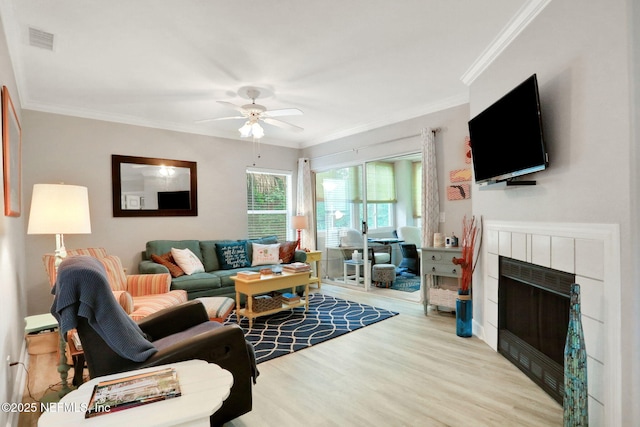 1800 The Greens Way Unit 605, Jacksonville Beach, FL 32250 - living area featuring wood finished floors, ceiling fan, a tile fireplace, and ornamental molding