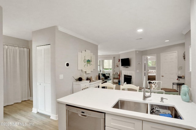 1800 The Greens Way Unit 605, Jacksonville Beach, FL 32250 - kitchen with dishwasher, white cabinetry, light countertops, ornamental molding, and light wood-style floors
