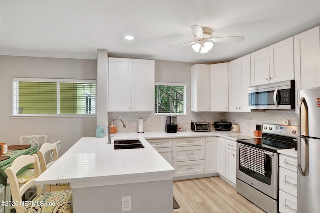 1800 The Greens Way Unit 605, Jacksonville Beach, FL 32250 - kitchen featuring appliances with stainless steel finishes, tasteful backsplash, a peninsula, light countertops, and recessed lighting